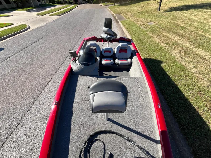 Slide: The Image of 2012 Tracker Pro Team 175 TXW boat with red trim, parked on a street. - 41