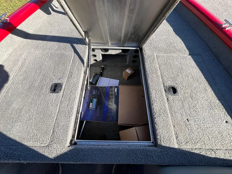 Slide: The Image of Open storage compartment on a 2012 Tracker Pro Team 175 TXW boat with various items inside. - 45