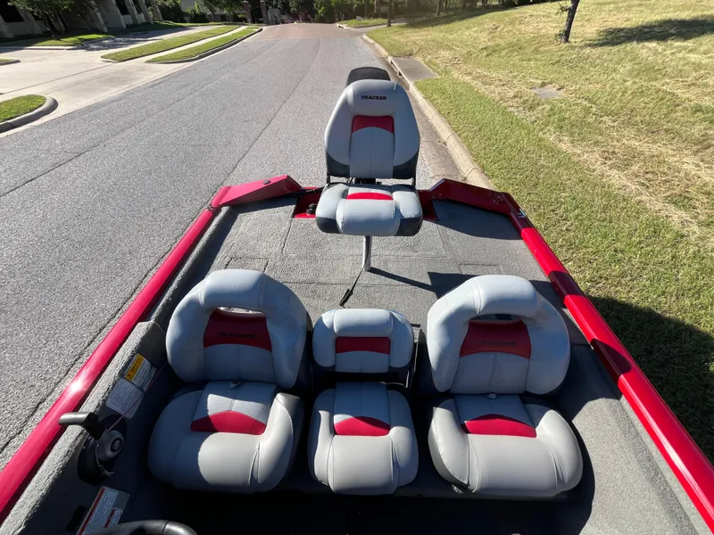 Slide: The Image of 2012 Tracker Pro Team 175 TXW boat with gray and red seating on a sunny street. - 48