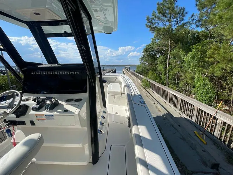 Slide: The Image of 2023 World Cat 260 CC-X boat interior with steering wheel, console, and scenic water view. - 10