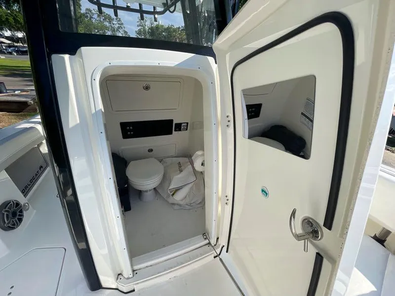 Slide: The Image of 2023 World Cat 260 CC-X boat interior with open door showing compact restroom. - 15