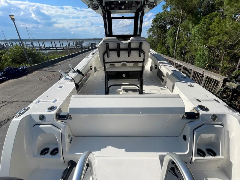 Slide: The Image of 2023 World Cat 260 CC-X boat interior with seating, dockside view, and lush greenery. - 6