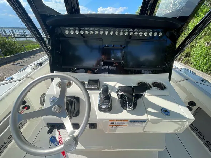 Slide: The Image of 2023 World Cat 260 CC-X boat dashboard with steering wheel and dual screens. - 7