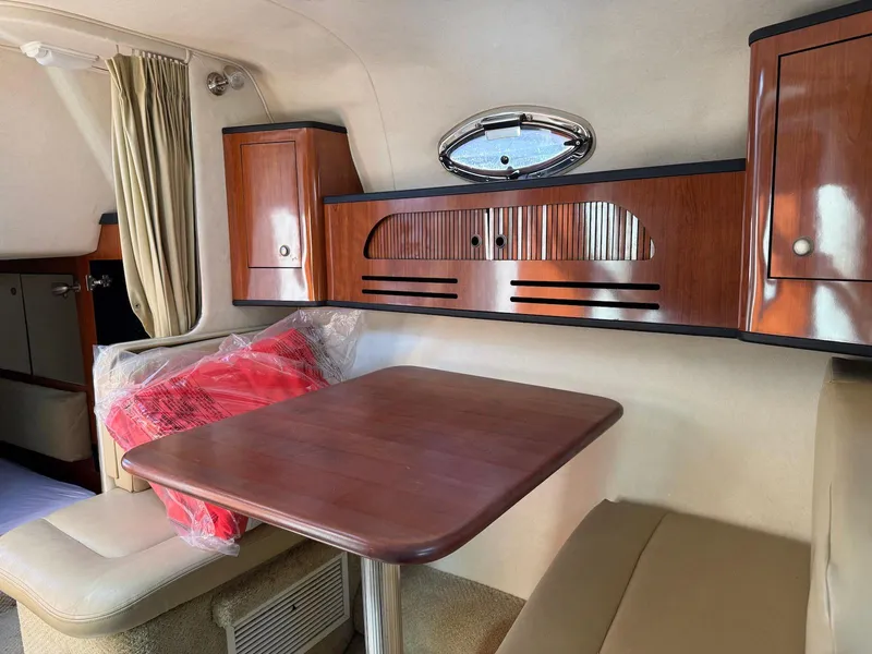 Slide: The Image of Interior of 2007 Sea Ray 280 Sundancer with wooden table and cabinets. - 10