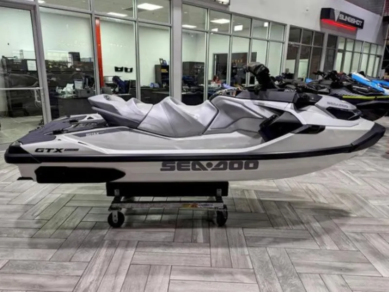 Slide: The Image of 2025 Sea-Doo GTX™ Limited 325 in White Pearl, displayed indoors on a showroom floor. - 2