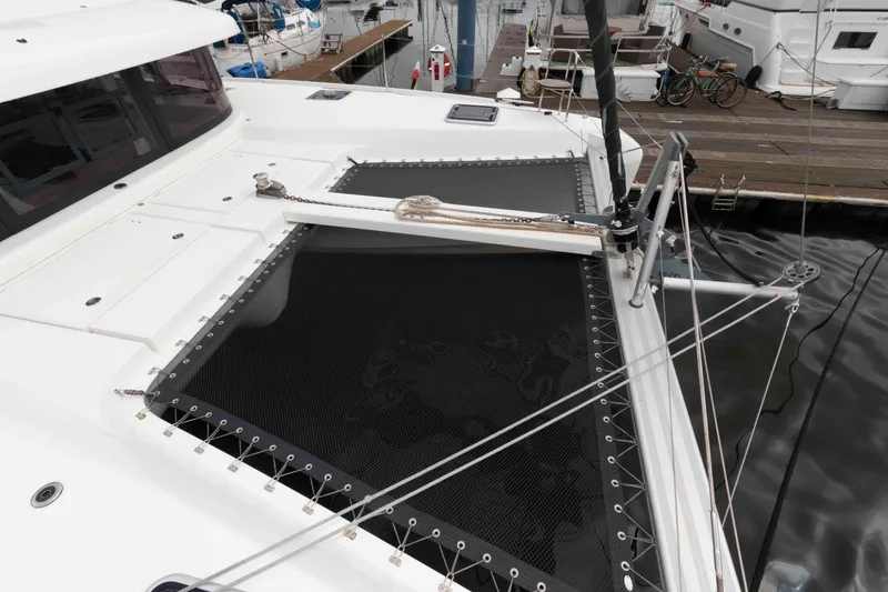 Slide: The Image of 2019 Lagoon 42 catamaran deck with netting, docked at marina. - 16