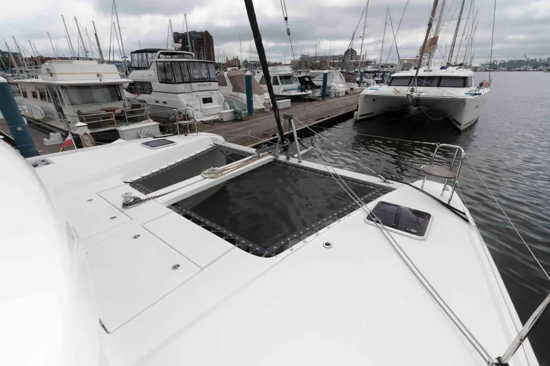 Slide: The Image of 2019 Lagoon 42 catamaran docked at marina, surrounded by other boats. - 17