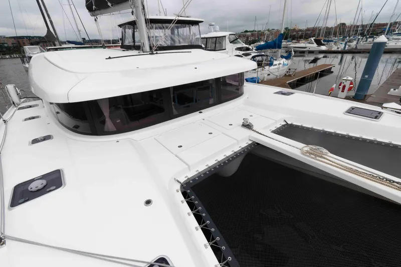 Slide: The Image of 2019 Lagoon 42 catamaran docked at marina, showcasing sleek design and spacious deck. - 18