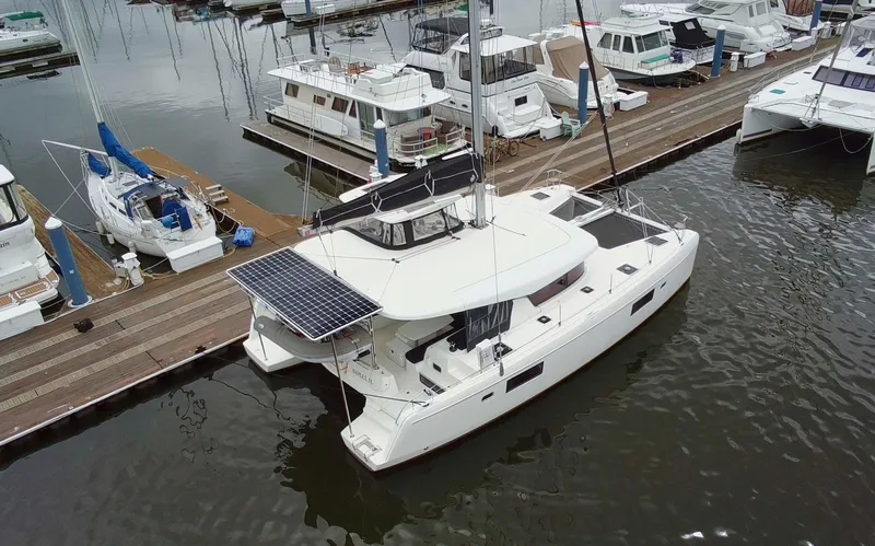 Slide: The Image of 2019 Lagoon 42 catamaran docked at marina with solar panels on deck. - 2