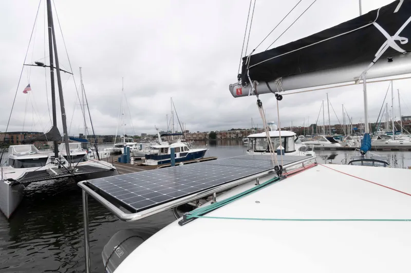 Slide: The Image of 2019 Lagoon 42 catamaran with solar panels docked at a marina. - 22