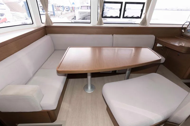 Slide: The Image of Interior of 2019 Lagoon 42 catamaran with cozy seating and wooden table. - 25