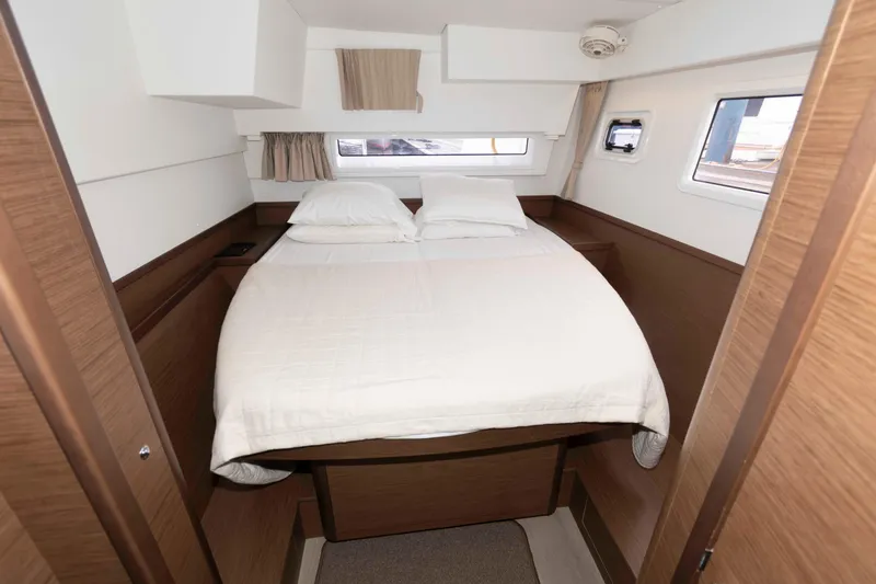 Slide: The Image of 2019 Lagoon 42 yacht cabin with cozy double bed and modern wooden interior. - 34