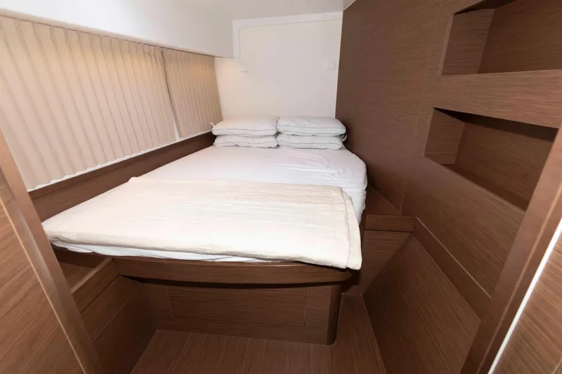 Slide: The Image of 2019 Lagoon 42 yacht cabin with cozy bed and wooden interior design. - 36
