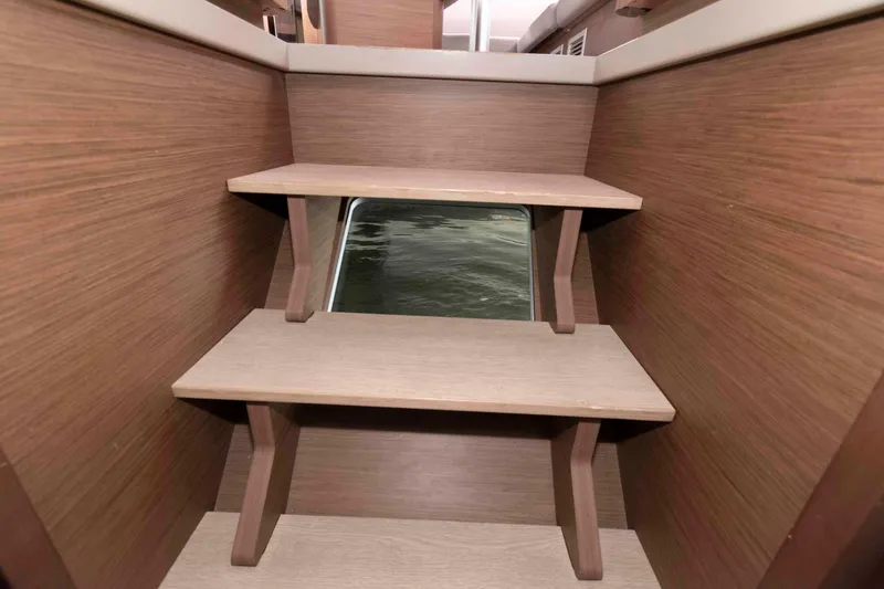 Slide: The Image of Interior wooden stairs on a 2019 Lagoon 42 catamaran with a window view. - 38