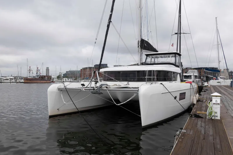 Slide: The Image of 2019 Lagoon 42 catamaran docked at a marina on a cloudy day. - 4