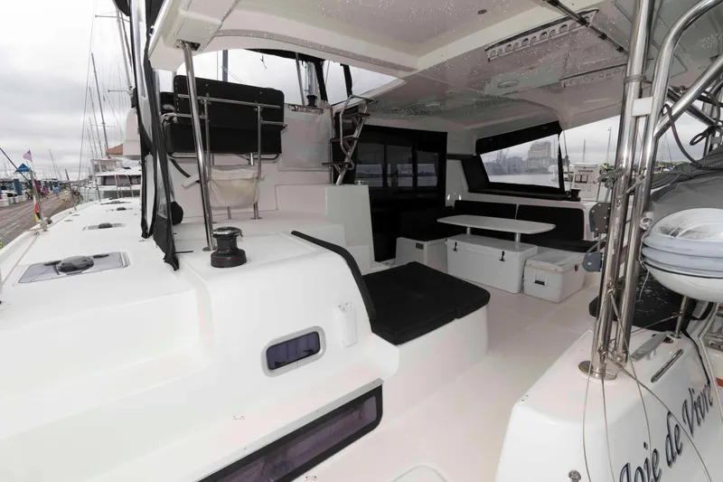 Slide: The Image of 2019 Lagoon 42 catamaran cockpit with seating and table, docked at marina. - 6