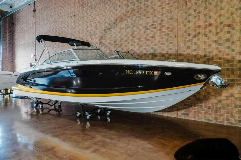 Slide: The Image of 2013 Cobalt A28 boat with black hull, displayed indoors against a brick wall. - 11
