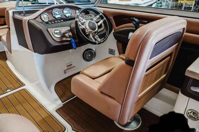 Slide: The Image of Interior of a 2013 Cobalt A28 boat with brown leather seating and modern dashboard. - 15