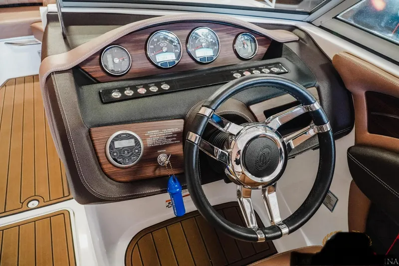 Slide: The Image of 2013 Cobalt A28 boat dashboard with wood accents and modern steering wheel. - 6