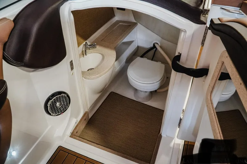 Slide: The Image of 2013 Cobalt A28 boat interior with compact bathroom, sink, and toilet. - 7