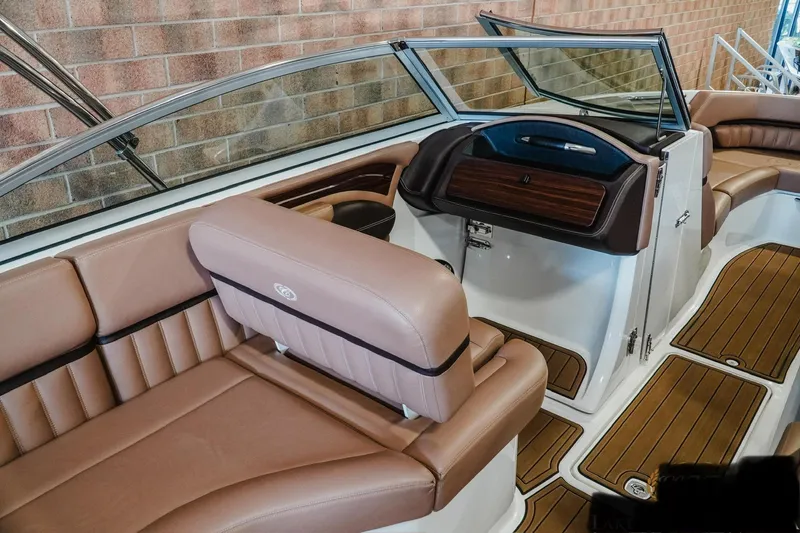 Slide: The Image of 2013 Cobalt A28 boat interior with tan leather seating and wood accents. - 8