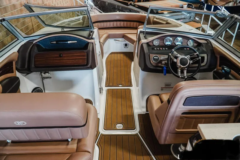 Slide: The Image of 2013 Cobalt A28 boat interior with brown leather seats and wooden dashboard. - 9