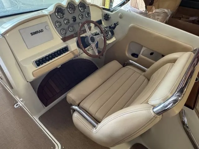 Slide: The Image of 2012 Chris-Craft Launch 28 boat interior with beige seating and classic dashboard. - 11