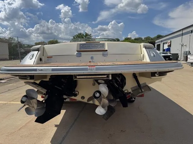 Slide: The Image of 2012 Chris-Craft Launch 28 boat rear view with dual propellers, parked outdoors. - 5