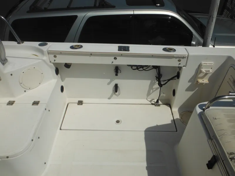 Slide: The Image of 2002 Robalo R235 Walkaround boat deck with storage and fishing rod holders. - 14