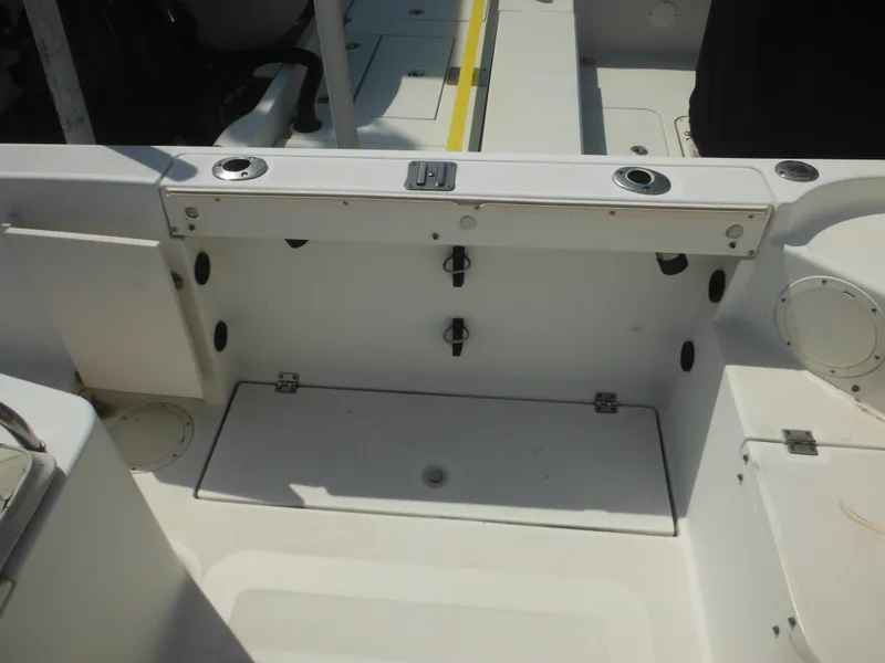 Slide: The Image of 2002 Robalo R235 Walkaround boat interior with storage compartments and seating area. - 15