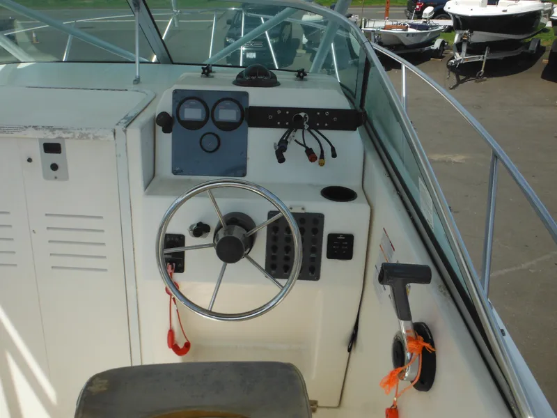 Slide: The Image of 2002 Robalo R235 Walkaround boat helm with steering wheel and control panel. - 19