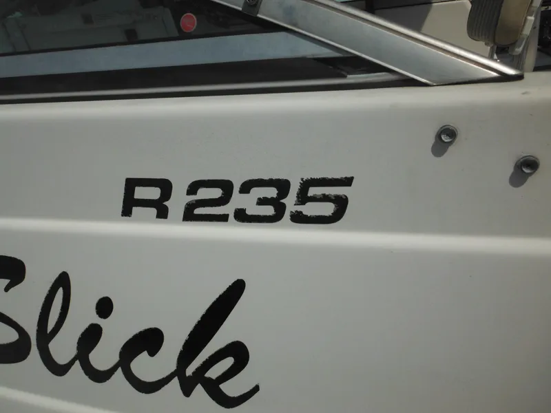 Slide: The Image of 2002 Robalo R235 Walkaround boat with visible model name on the side. - 22