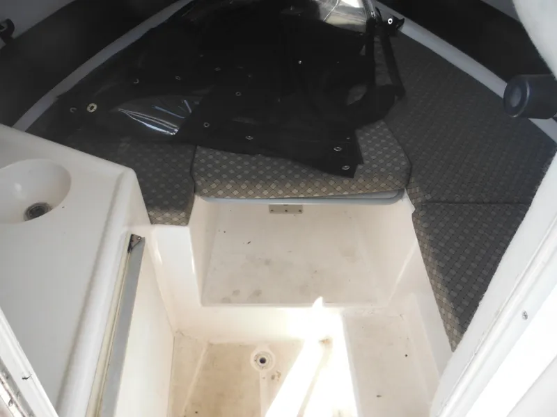 Slide: The Image of 2002 Robalo R235 Walkaround cabin interior with cushioned seating and compact sink. - 29