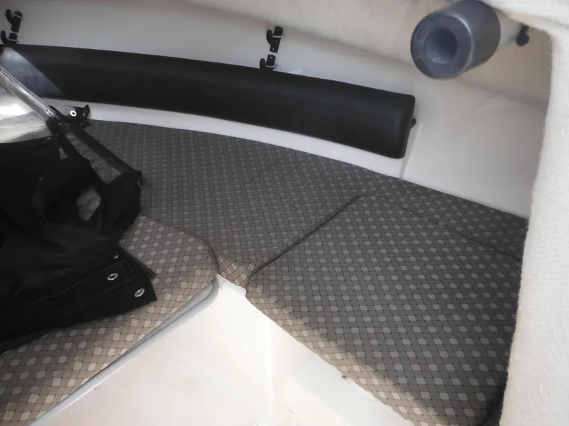 Slide: The Image of 2002 Robalo R235 Walkaround cabin interior with cushioned seating and storage. - 31