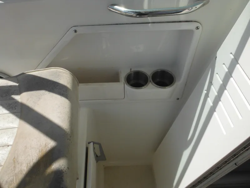 Slide: The Image of 2002 Robalo R235 Walkaround boat interior with cup holders and storage compartment. - 33