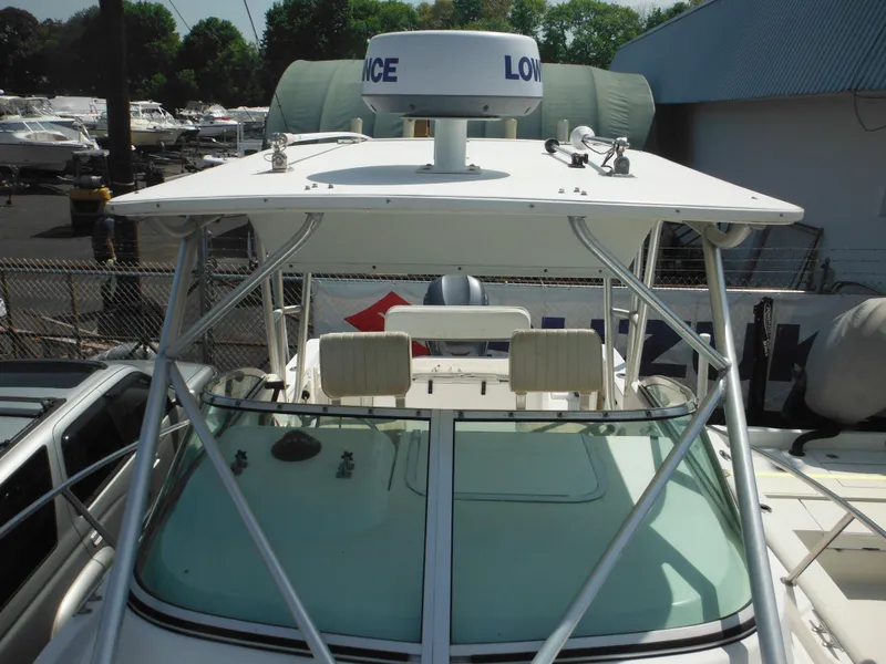 Slide: The Image of 2002 Robalo R235 Walkaround boat with radar, docked in a marina. - 36