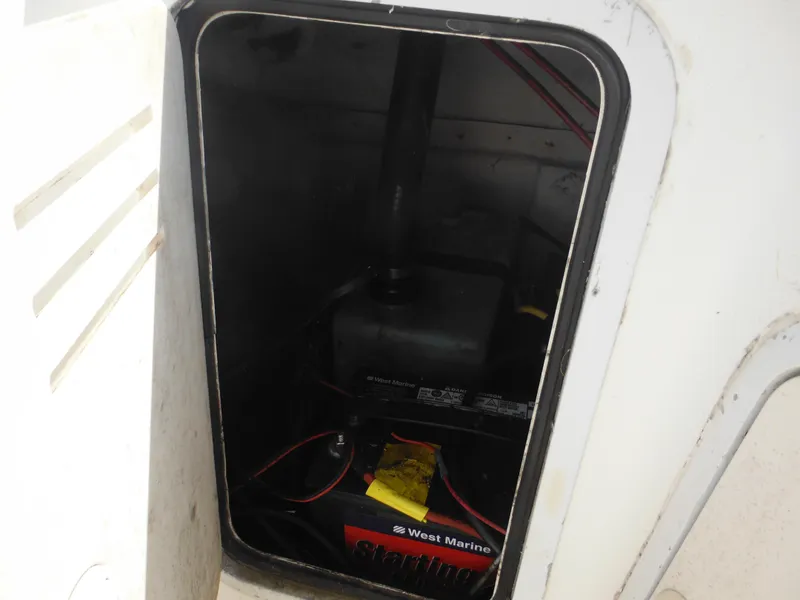 Slide: The Image of 2002 Robalo R235 Walkaround boat compartment with marine battery and wiring. - 44