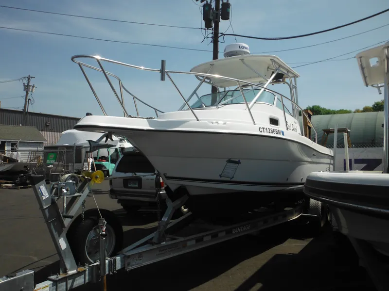 Slide: The Image of 2002 Robalo R235 Walkaround boat on trailer in a marina setting. - 46