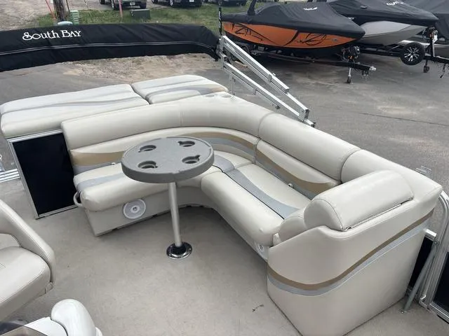 Slide: The Image of 2015 South Bay 420 CR pontoon boat with beige seating and a round table. - 9