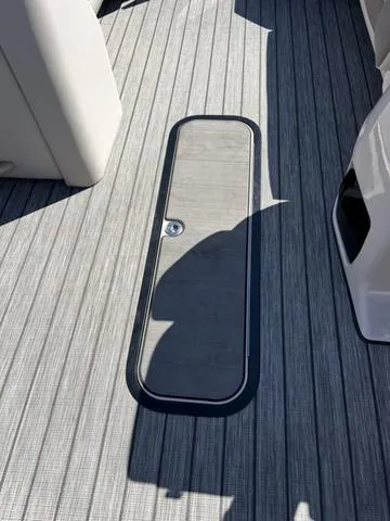 Slide: The Image of 2025 Harris SUNLINER 230 SLDH boat deck with sleek, modern design and storage hatch. - 8