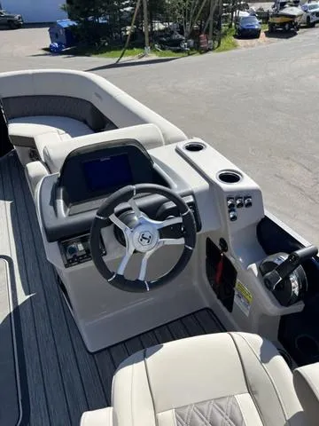 Slide: The Image of 2025 Harris SUNLINER 230 SLDH boat interior with steering wheel and control panel. - 9