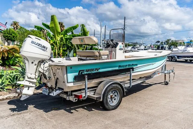 Slide: The Image of 2018 Carolina Skiff 16JVX boat on trailer with Suzuki outboard motor, parked outdoors. - 3