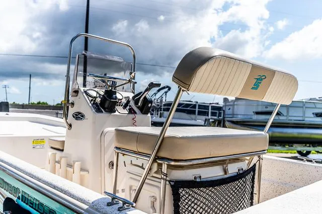 Slide: The Image of 2018 Carolina Skiff 16JVX boat with console and seating, under a cloudy sky. - 8