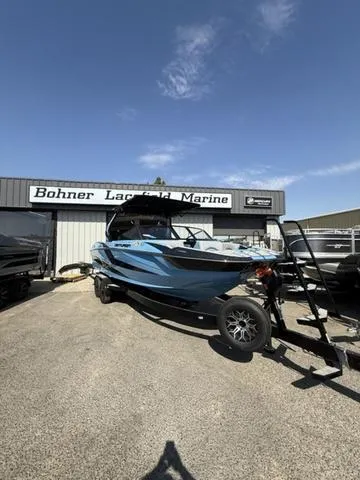 Slide: The Image of 2025 Centurion Fe25 boat cruising under a bridge on a scenic river. - 1