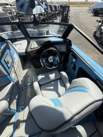 Slide: The Image of 2025 Centurion Fe25 boat interior with blue and gray seating, modern dashboard, and steering wheel. - 14