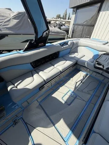 Slide: The Image of 2025 Centurion Fe25 boat interior with blue and gray seating, docked near a building. - 6