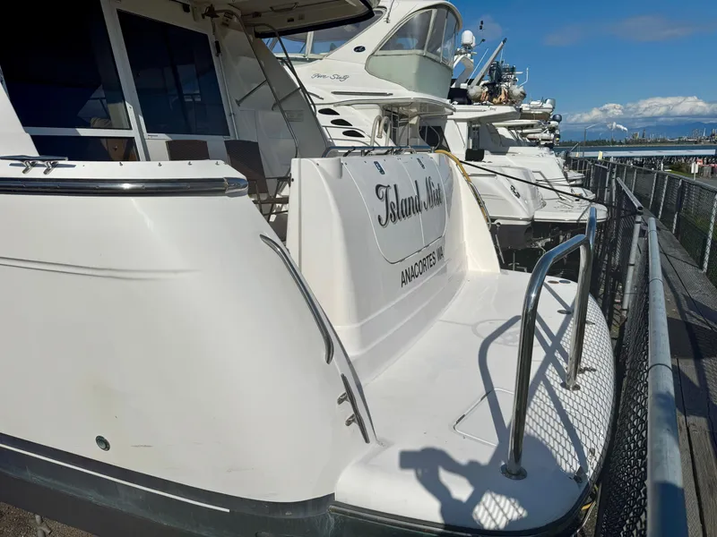 Slide: The Image of 1999 Bayliner 5288 Pilot House Motoryacht docked, featuring sleek design and spacious deck. - 1