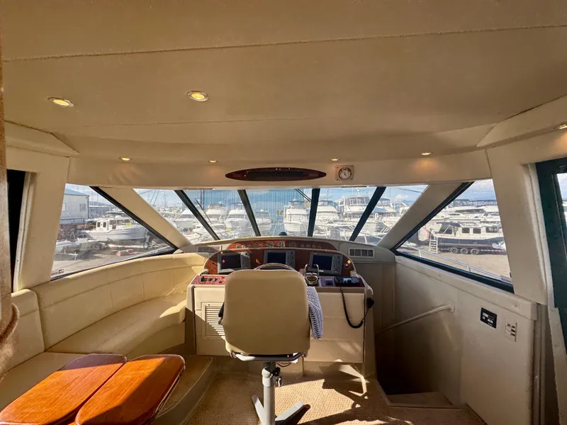 Slide: The Image of 1999 Bayliner 5288 Pilot House Motoryacht interior with helm, seating, and panoramic windows. - 12