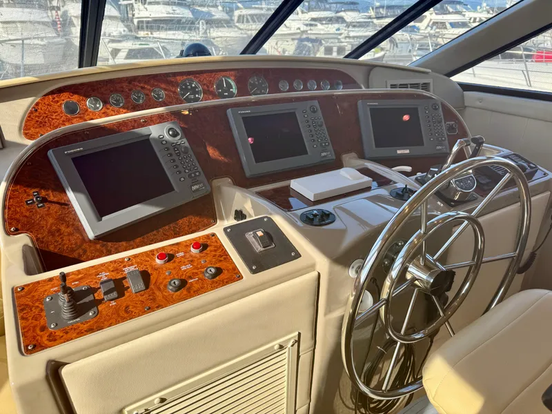 Slide: The Image of 1999 Bayliner 5288 Pilot House Motoryacht helm with navigation screens and steering wheel. - 16