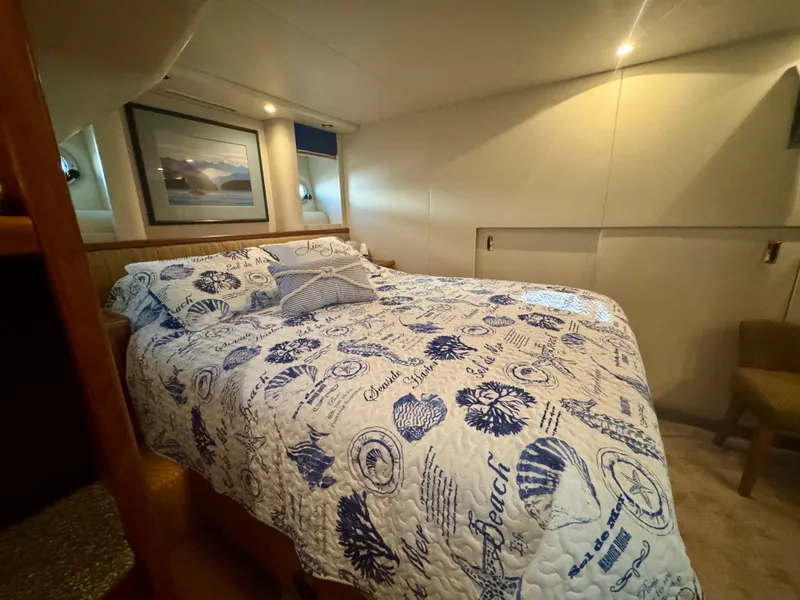 Slide: The Image of 1999 Bayliner 5288 Pilot House Motoryacht bedroom with nautical-themed bedding and cozy lighting. - 28